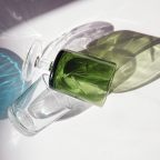 transparent and green glass bottles lying on top of a white table